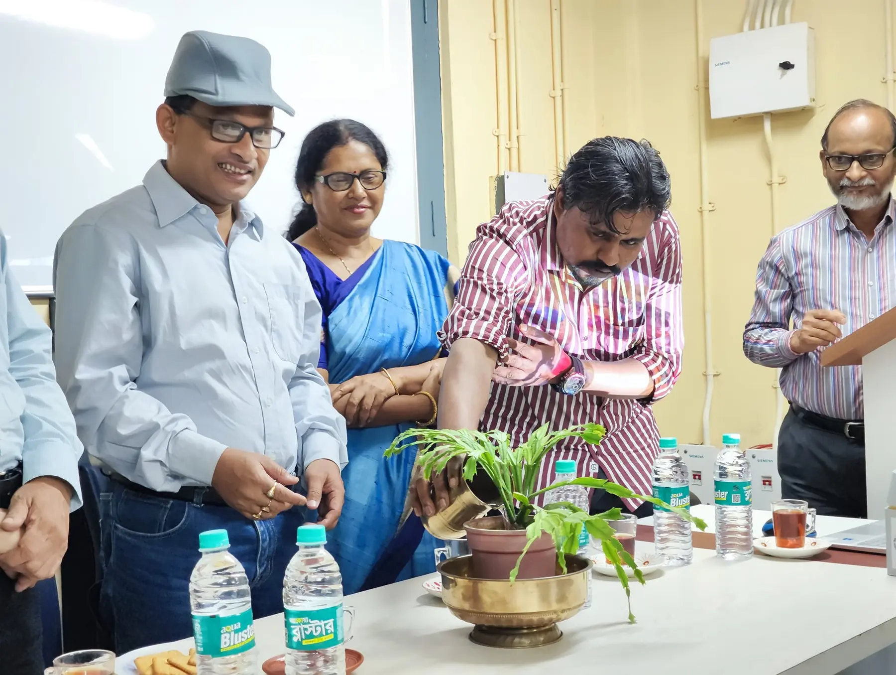 Ceremonial watering of a plant during an institutional programme